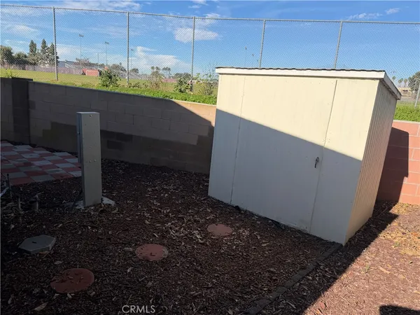 a room with water heater and wooden cabinets