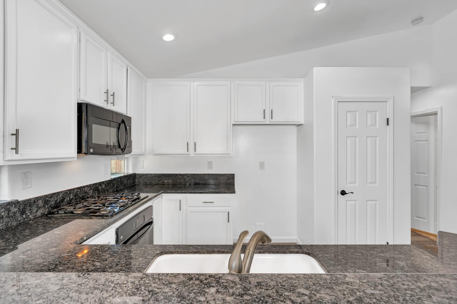 13612 Dromore Court Bakersfield, CA 93314 - Photo 13 of 35 a kitchen with granite countertop a sink and a stove top oven