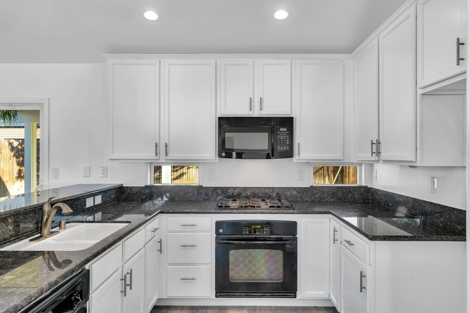 13612 Dromore Court Bakersfield, CA 93314 - Photo 14 of 35 a kitchen with granite countertop white cabinets and stainless steel appliances