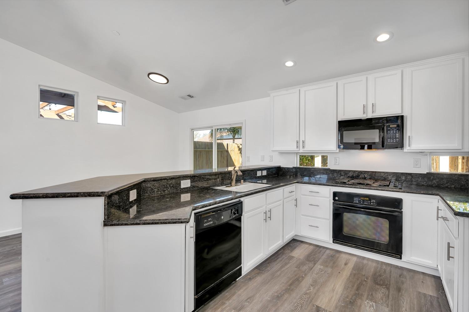 13612 Dromore Court Bakersfield, CA 93314 - Photo 15 of 35 a kitchen with granite countertop a sink a stove and cabinets