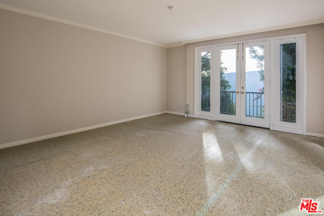 2237 Canyonback Road Los Angeles, CA 90049 - Photo 22 of 34 an empty room with large windows
