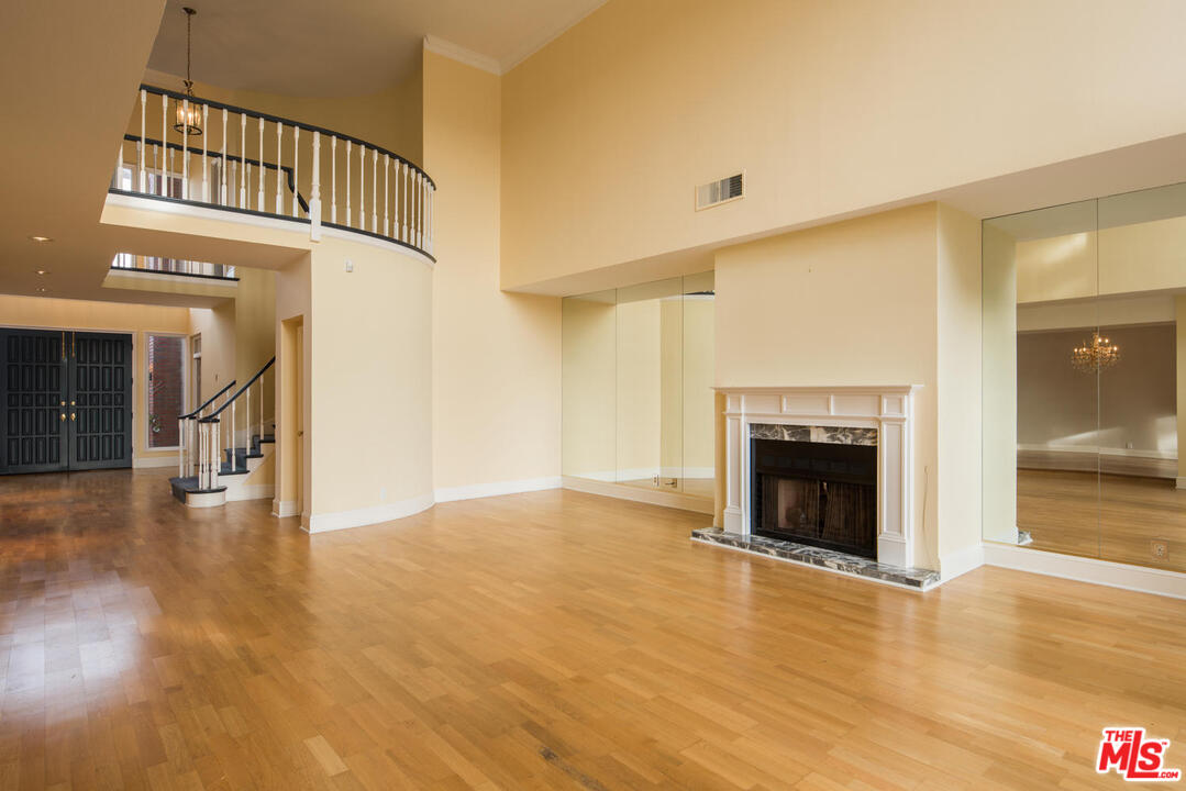 2237 Canyonback Road Los Angeles, CA 90049 - Photo 8 of 34 a view of an empty room with wooden floor fireplace and a window