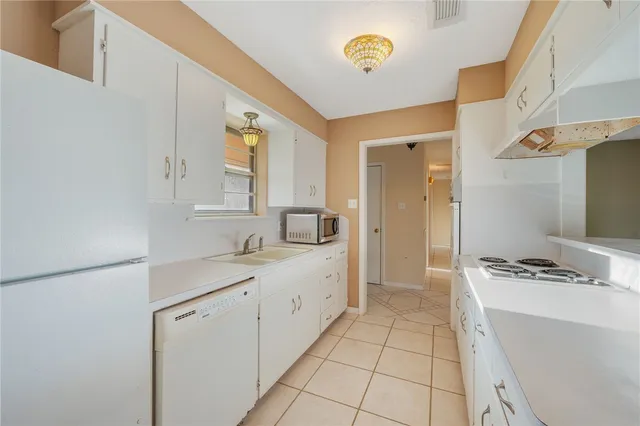 a kitchen with a sink a stove cabinets and a window