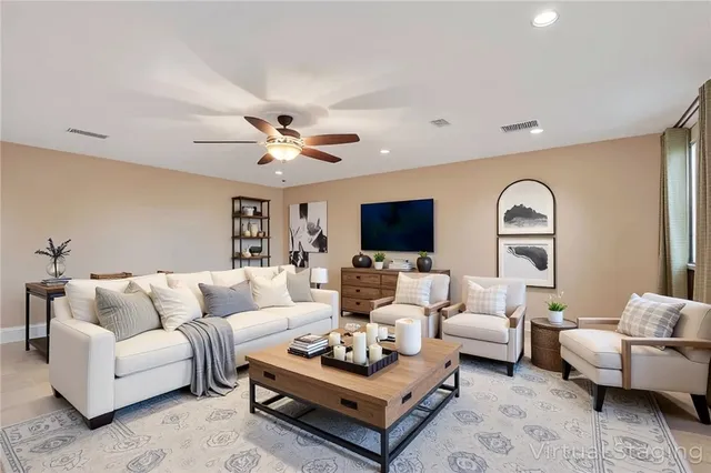 a living room with furniture ceiling fan and a rug