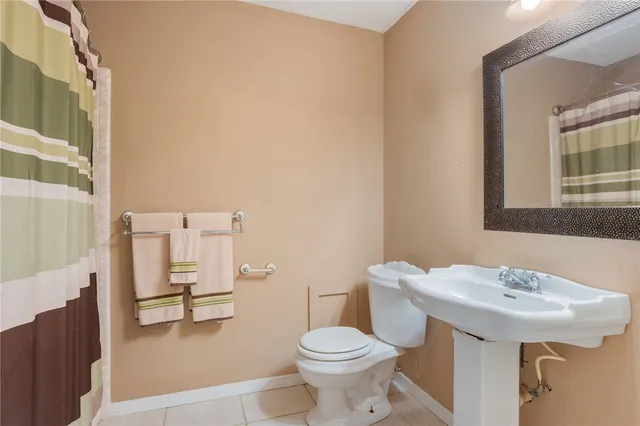a bathroom with a sink toilet and a mirror
