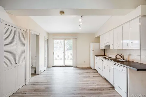 a large kitchen with stainless steel appliances granite countertop a sink and cabinets with wooden floors