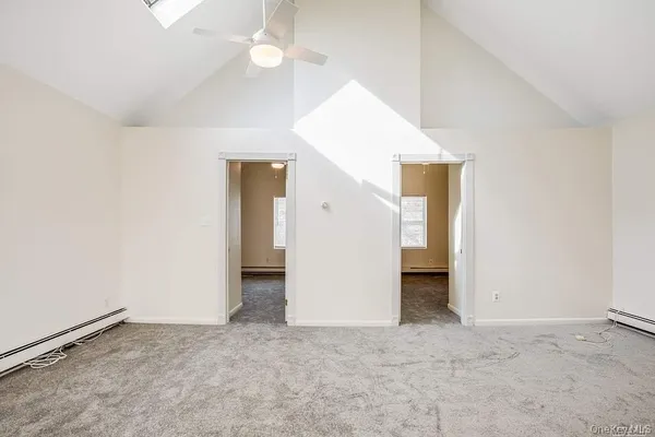 an empty room with a chandelier fan and closet