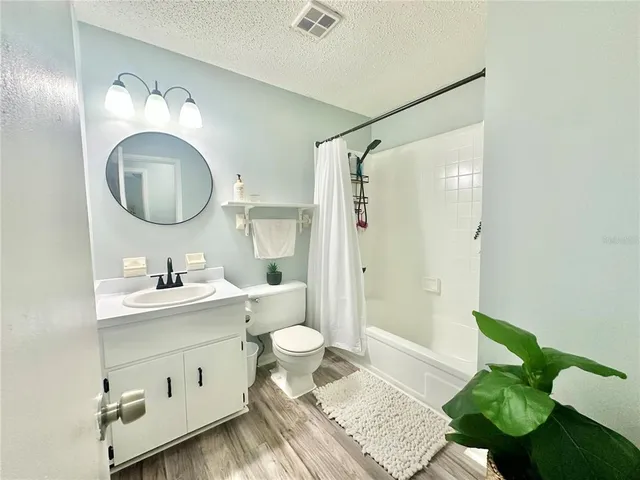 a bathroom with a granite countertop sink mirror and a toilet