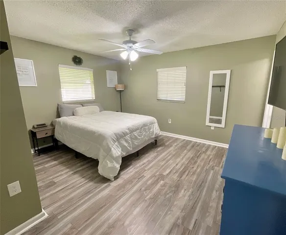 a bedroom with a bed and a flat tv screen on dresser