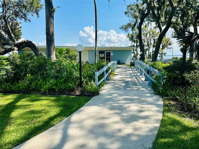 a front view of a house with a yard and potted plants