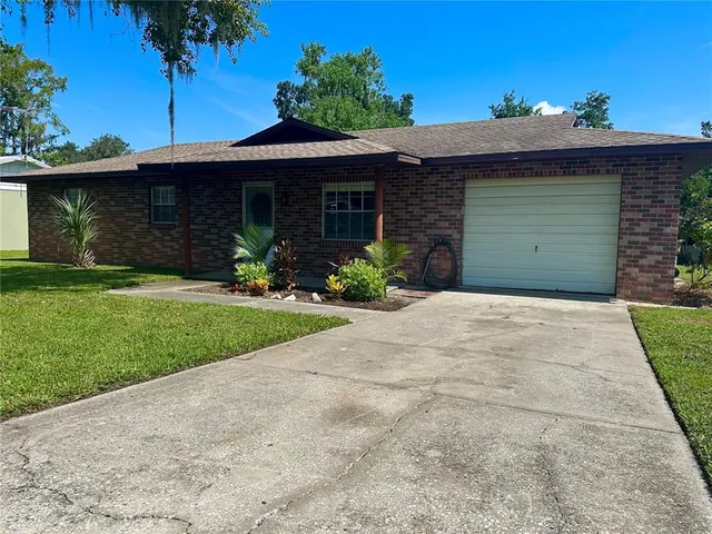 a front view of a house with a garden and yard