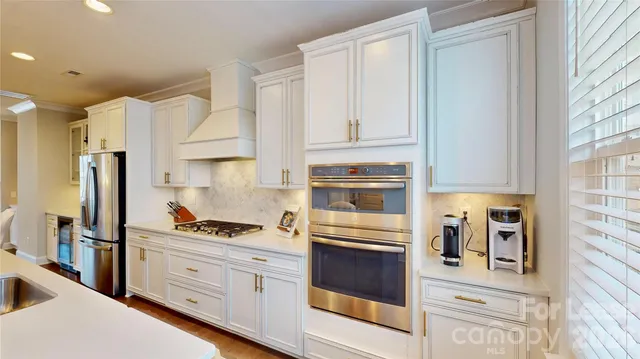 a kitchen with stainless steel appliances granite countertop a refrigerator and a stove
