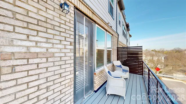 a view of balcony with wooden floor and seating space
