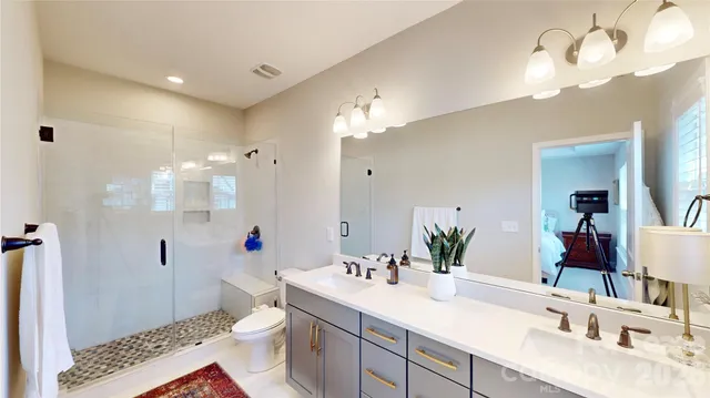 a bathroom with a double vanity sink mirror and toilet