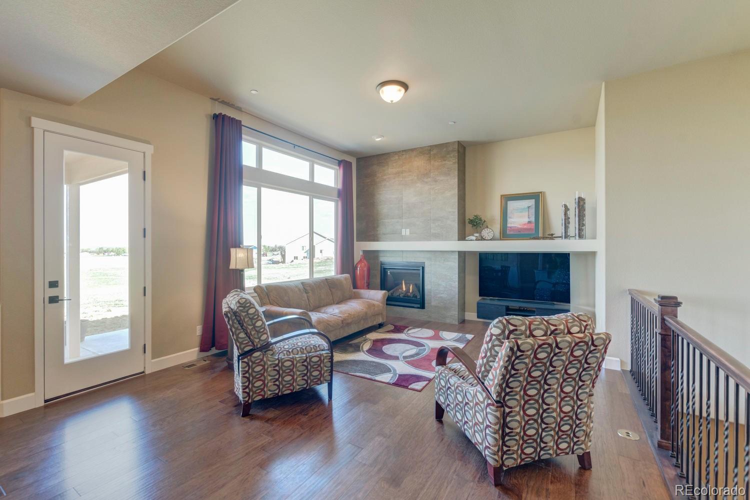 4188 Meadowlark Road Fort Lupton, CO 80621 - Photo 13 of 36 a living room with furniture and a fireplace