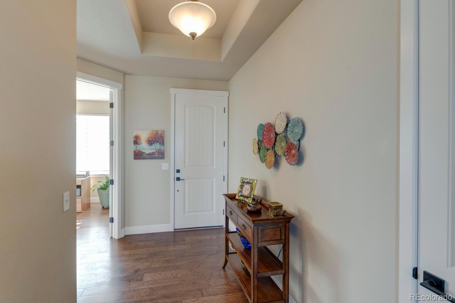 4188 Meadowlark Road Fort Lupton, CO 80621 - Photo 15 of 36 a view of a hallway with wooden floor and a workspace