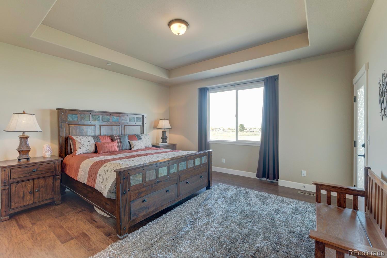 4188 Meadowlark Road Fort Lupton, CO 80621 - Photo 19 of 36 a bedroom with a bed and a table in it