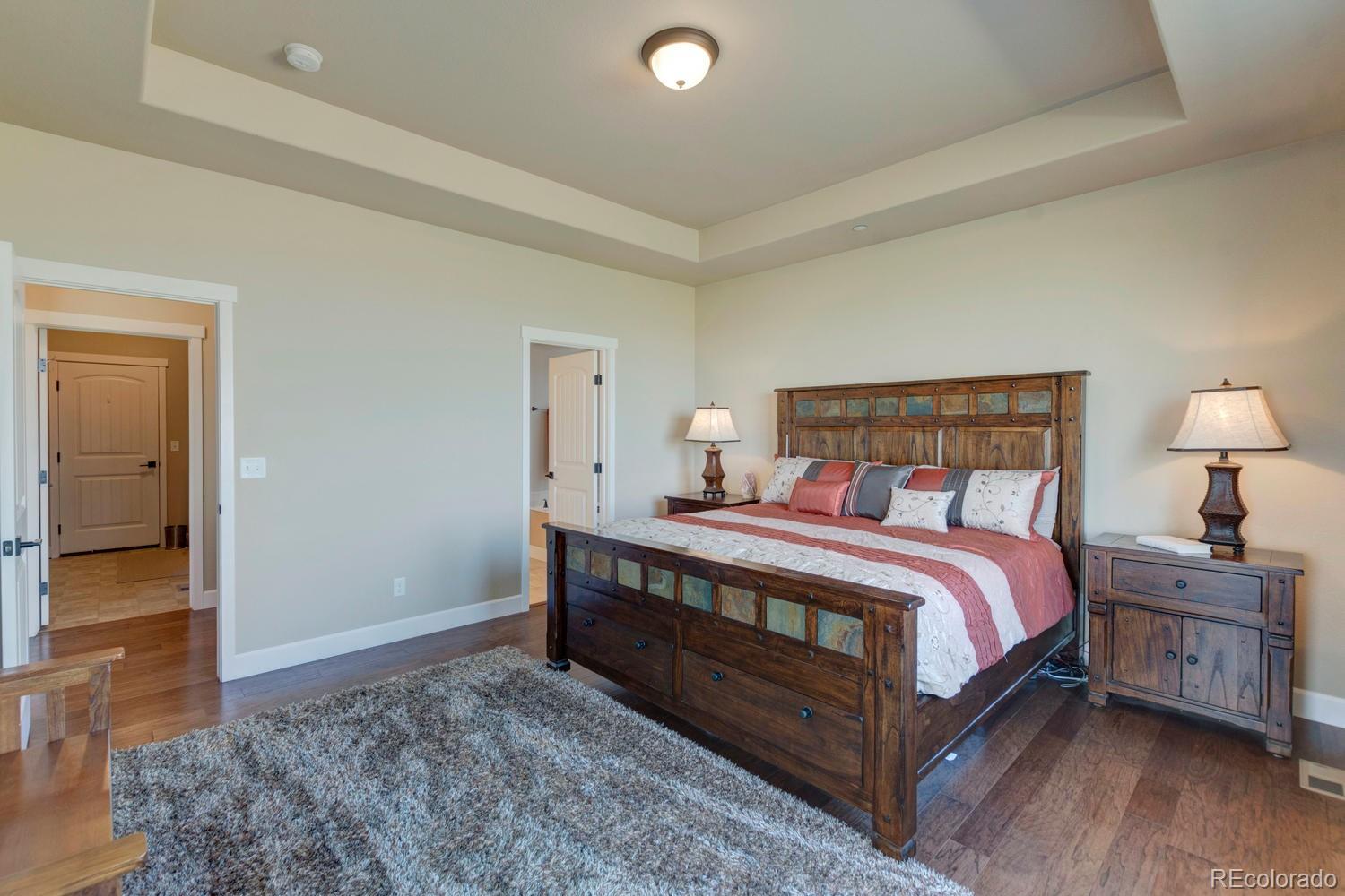 4188 Meadowlark Road Fort Lupton, CO 80621 - Photo 20 of 36 a bedroom with a bed and a lamp on table