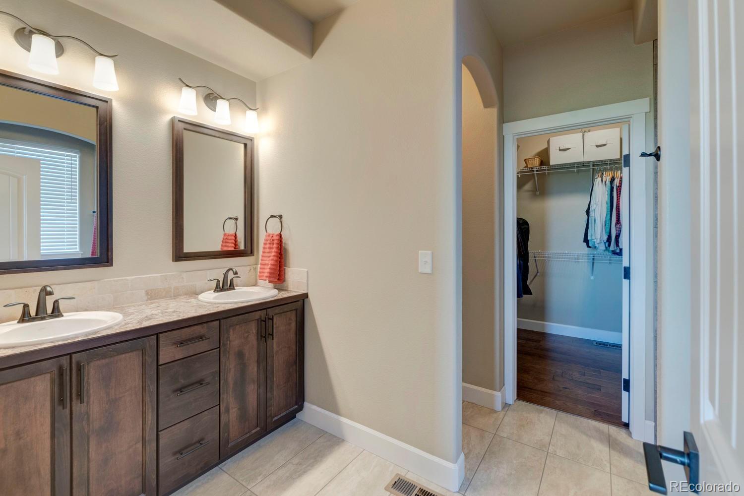 4188 Meadowlark Road Fort Lupton, CO 80621 - Photo 21 of 36 a bathroom with a double vanity sink and mirror