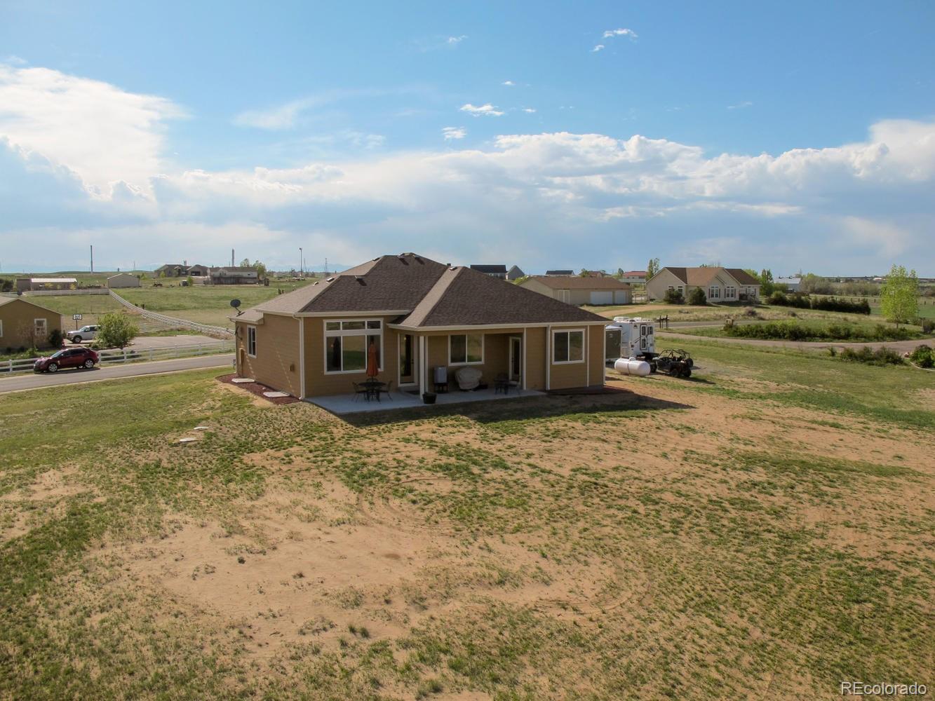 4188 Meadowlark Road Fort Lupton, CO 80621 - Photo 32 of 36 a view of a lake with a big yard and large trees