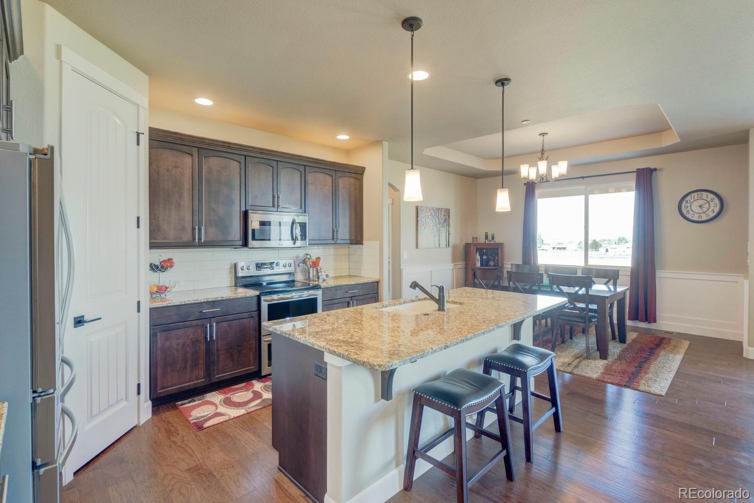 4188 Meadowlark Road Fort Lupton, CO 80621 - Photo 8 of 36 a large kitchen with a table and chairs