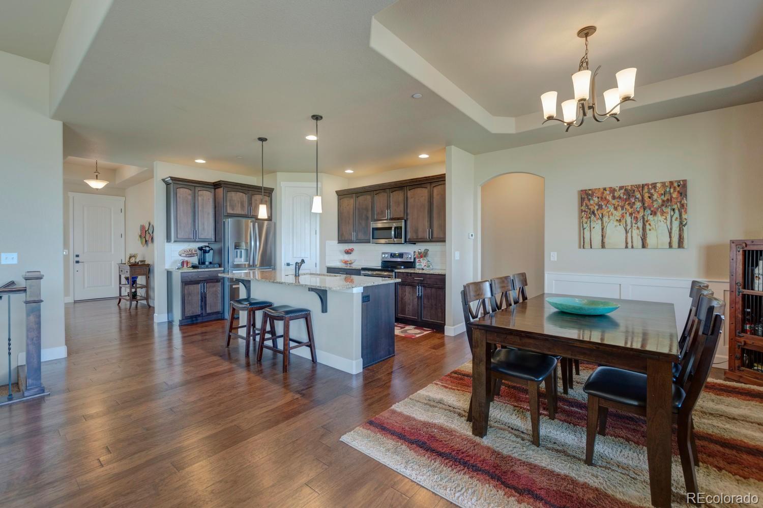 4188 Meadowlark Road Fort Lupton, CO 80621 - Photo 9 of 36 a view of a dining room with furniture and wooden floor