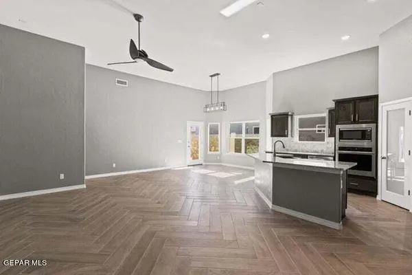 a view of a kitchen with a sink and dishwasher a refrigerator with wooden floor