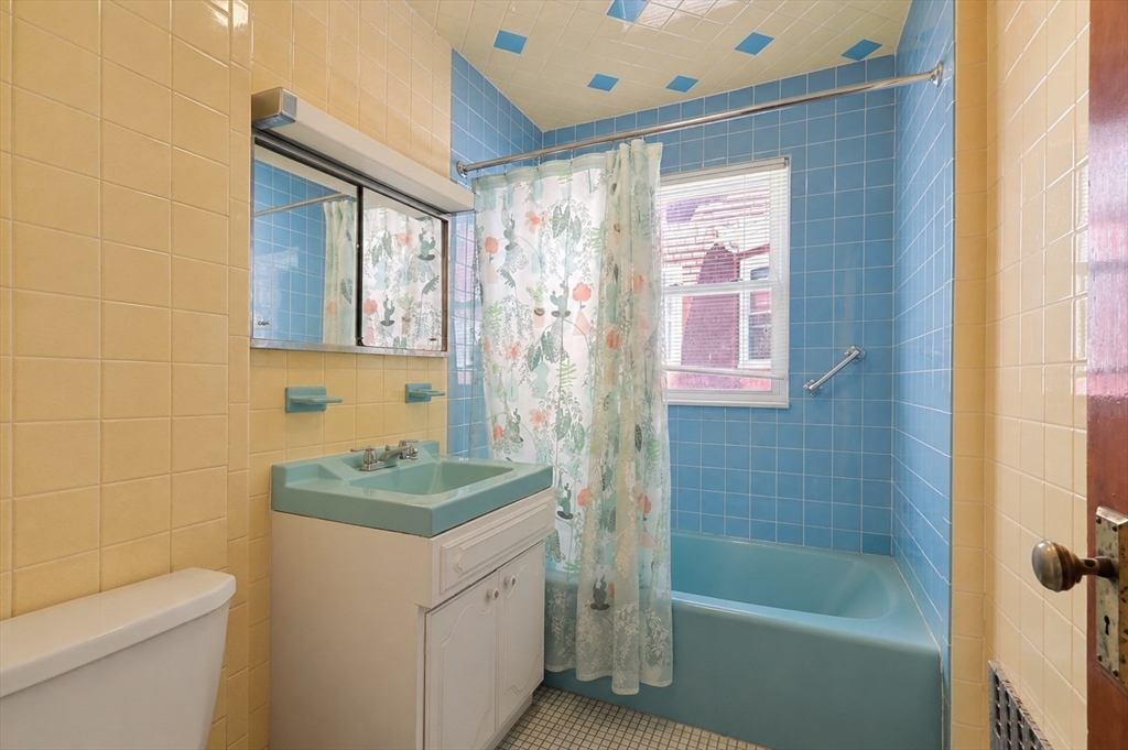 157 Elm Street Somerville, MA 02144 - Photo 11 of 19 a bathroom with a granite countertop sink a toilet a shower and a mirror