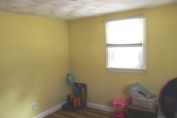 a view of a small space with wooden floor and a window