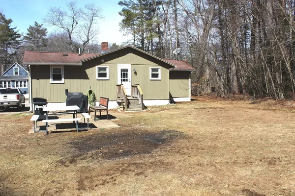 a view of a house with backyard and sitting area