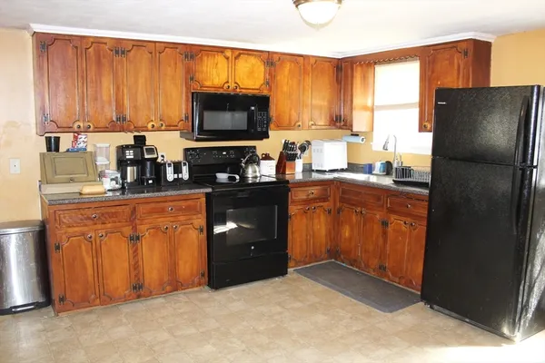 a kitchen with stainless steel appliances granite countertop a refrigerator stove top oven a sink and dishwasher
