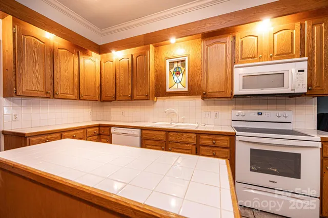 a kitchen with stainless steel appliances granite countertop a stove a sink and a microwave