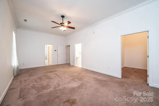 an empty room with closet and a ceiling fan