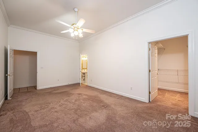 an empty room with closet and a chandelier fan