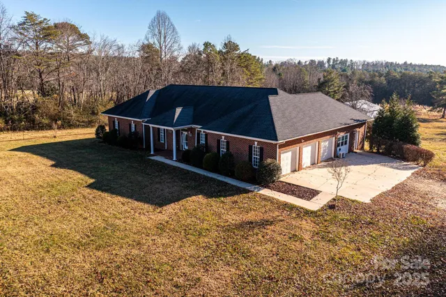 a view of house with yard and trees in the background