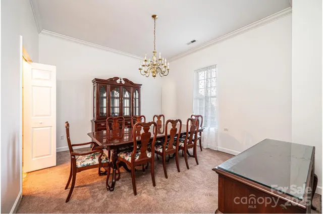 a view of a dining room with furniture and chandelier