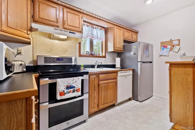 a kitchen with stainless steel appliances granite countertop a stove a refrigerator and a microwave