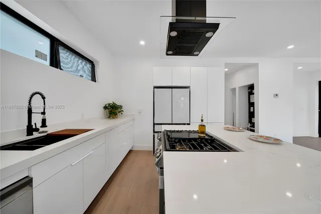 a kitchen with a sink and white cabinets