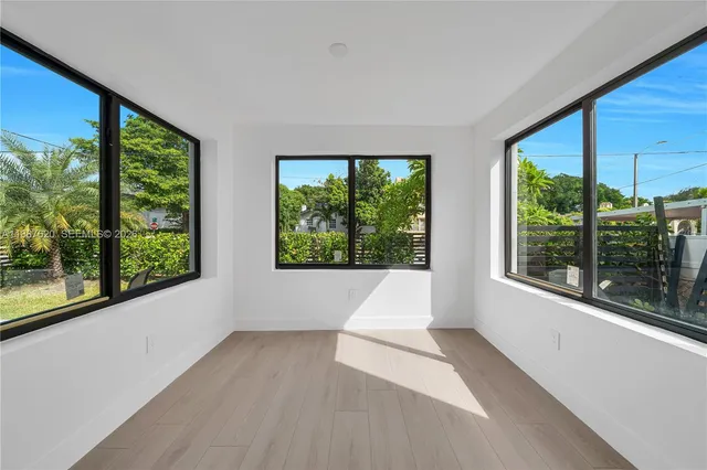 a view of an empty room with wooden floor and doors
