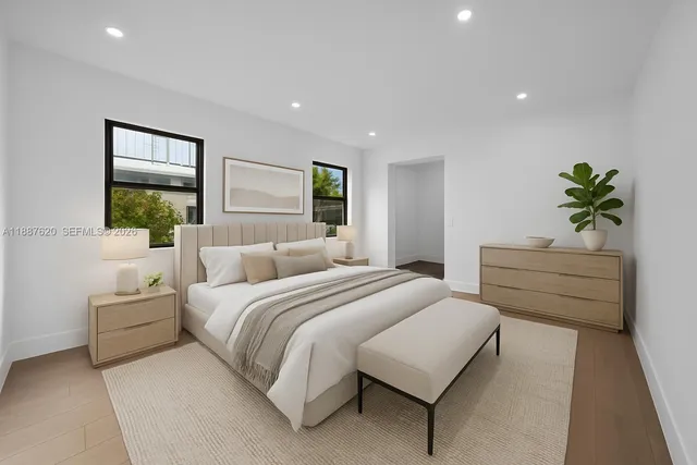 a spacious bedroom with a large bed and a potted plant