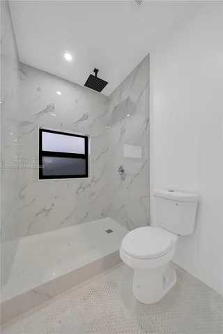 a white toilet sitting next to a bath tub