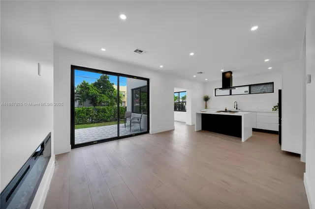 a view of a big room with wooden floor and windows