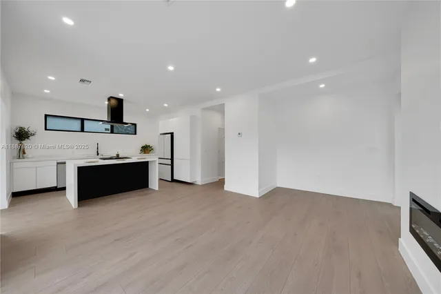 a view of kitchen with refrigerator and window