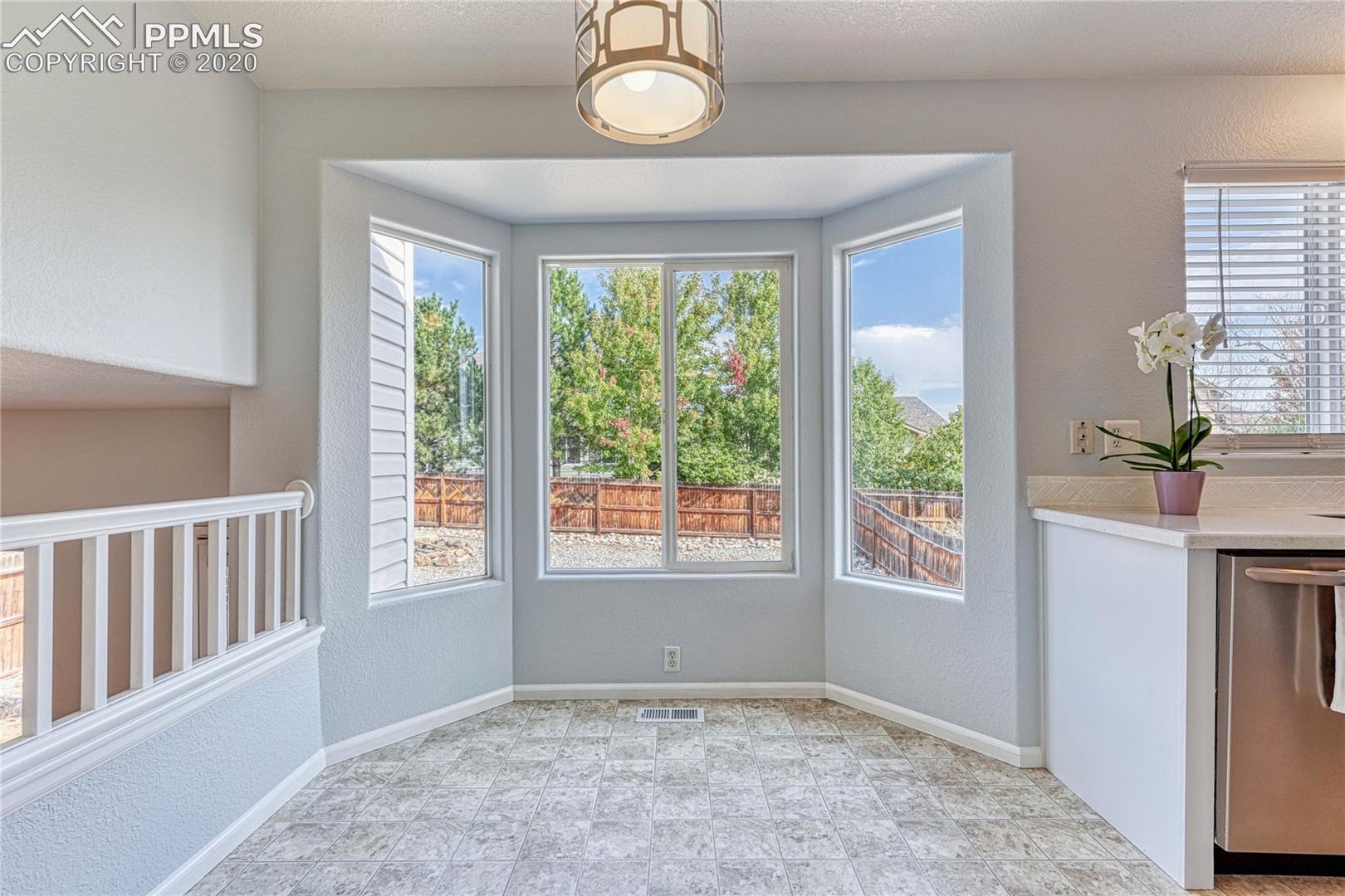6554 Hannah Rose Road Colorado Springs, CO 80923 - Photo 7 of 29 Dining area with bay window, backyard views and updated lighting.
