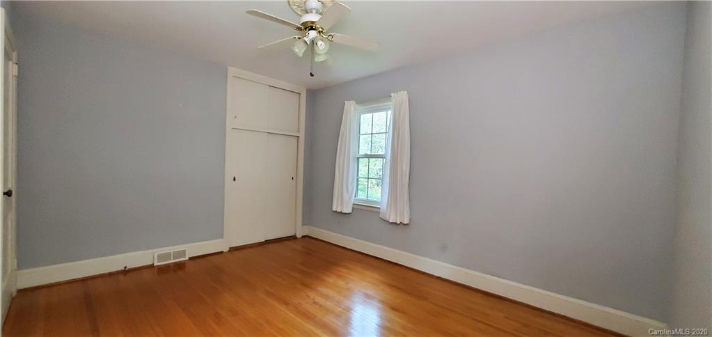 2221 Arnold Drive Charlotte, NC 28205 - Photo 18 of 23 an empty room with a window and chandelier fan