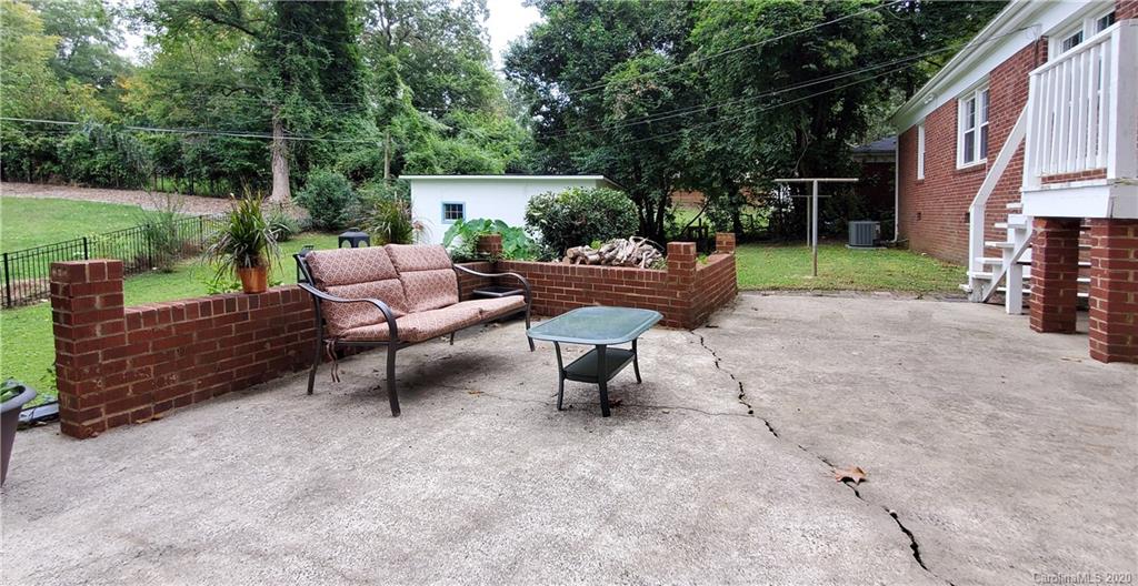 2221 Arnold Drive Charlotte, NC 28205 - Photo 21 of 23 a view of a patio with table and chairs with wooden fence and plants