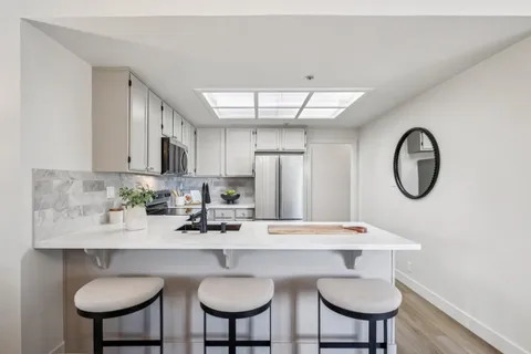 a kitchen with stainless steel appliances a table and chairs