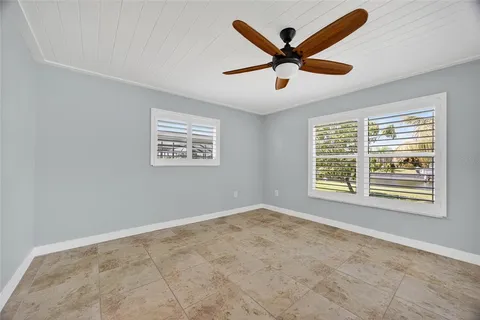 a view of an empty room with a ceiling fan and a window