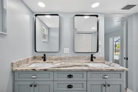 a bathroom with a granite countertop sink vanity and mirror