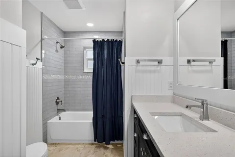 a bathroom with a tub sink and mirror